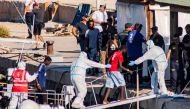One of the twenty-seven unaccompanied minors aboard the Guardia di Finanza boat arrive at Italian island of Lampedusa on August 17, 2019 after being evacuated off the Spanish migrant NGO rescue ship Open Arms, moored off the coast of the island. AFP / Ale