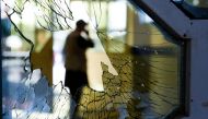 (FILES) In this file photo taken on August 18, 2019, a man is seen through a broken window of a wedding hall after a deadly bomb blast in Kabul. AFP / Wakil Kohsar  