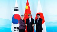 Chinese Foreign Minister Wang Yi (C), South Korean Foreign Minister Kang Kyung-wha (L) and Japanese Foreign Minister Taro Kono (R) shake hands ahead the ninth trilateral foreign ministers' meeting among China, South Korea and Japan at Gubei Town in Beijin