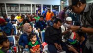 Passengers of a ferry that caught fire gather at Tangjung Perak seaport, after being evacuated, in Surabaya, East Java, on August 23, 2019. AFP / JUNI KRISWANTO