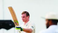 New Zealand's cricketer Tom Latham (L) raises his bat after he scored a century (100 runs) during the third day of the final cricket Test match between Sri Lanka and New Zealand at P. Sara Oval cricket stadium in Colombo on August 24, 2019. AFP / Lakruwan