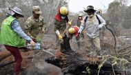 Soldiers, firemen and volunteers combat forest fires in the surroundings of Robore in eastern Bolivia, on August 25, 2019.  AFP / Aizar Raldes
 