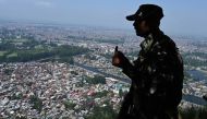 An Indian paramilitary trooper patrols at the top of a hill in Srinagar on August 25, 2019. / AFP / Tauseef Mustafa