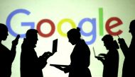 Silhouettes of laptop and mobile device users are seen next to a screen projection of Google logo in this picture illustration, March 28, 2018. Reuters / Dado Ruvic