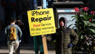 A man displays an advertisement for repairing iPhones in New York on October 19, 2015. AFP / Jewel Samad 