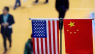 (FILES) This file picture taken on November 6, 2018, shows a Chinese and US flag at a booth during the first China International Import Expo in Shanghai. AFP / Johannes Eisele 