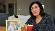 Anna Amato sits for a portrait next to a photograph of her parents Mario and Chiara at her home in Bristol, Britain, August 28, 2019. Picture taken August 28, 2019. Reuters/Toby Melville