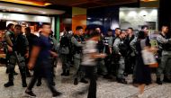 Riot police wait at a Mass Transit Railway (MTR) station as commuters walk past to catch a subway train, in Hong Kong, China, September 2, 2019. REUTERS/Anushree Fadnavis