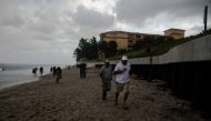 People are seen running from pouring rain on the shore while there are mandatory evacuation orders for parts of Palm Beach County in Lantana Beach, Florida on September 1, 2019. AFP / Eva Marie UZCATEGUI