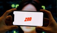 The logo of the Chinese app ZAO, which allows users to swap their faces with celebrities and anyone else, is seen on a mobile phone screen in front of an advertisement of the app, in this illustration picture taken September 2, 2019. REUTERS/Florence Lo/I