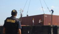 (FILES) This file photo dated July 29, 2019 shows Indonesian custom officers preparing to return containers filled with hazardous rubbish to their countries of origin, in Batam. AFP / SEI RATIFA