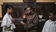 Vicar at the Our Lady of the Rosary Cathedral, Father Alfredo Manhica (C), blesses a Rosary in Beira, central Mozambique on August 20, 2019. AFP / Marco Longari 