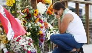 A woman looks emotional as she kneels at a makeshift memorial in Santa Barbara Harbor for victims of the Conception boat fire on September 3, 2019 in Santa Barbara, California. Mario Tama/Getty Images/AFP 