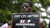 A demonstrator holds a sign during a protest against xenophobia outside of the main gate of the South African High Commission which was shut down to avert reprisal attacks in Abuja, on September 5, 2019.  AFP / Kola Sulaimon
 