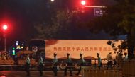 Paramilitary police march past trucks with propaganda slogans on Beijing's Changan Avenue, the city's main east-west boulevarde, during an overnight rehearsal of a military parade to mark Communist China's 70th anniversary, in Beijing on September 7, 2019