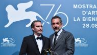 US director Todd Phillips (R), flanked by US actor Joaquin Phoenix, holds the Golden Lion award for Best Film he received for the movie