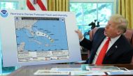 US President Donald Trump holds a chart showing the original projected track of Hurricane Dorian that appears to have been extended with a black line to include parts of the Florida panhandle and of the state of Alabama during a status report meeting on t