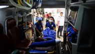 This photo taken on July 18, 2019 shows first responders loading a patient into their ambulance at a bus station near Manila. AFP / Noel Celis 