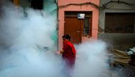A woman covers her face as she walks away after a worker fumigated a resident area to prevent the spread of the dengue fever and other mosquito-borne diseases in Kathmandu, Nepal September 5, 2019. Reuters/Navesh Chitrakar
 
