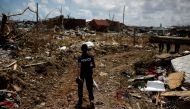 FILE PHOTO: A police officer searches for the dead in the destroyed Mudd neighborhood after Hurricane Dorian hit the Abaco Islands in Marsh Harbour, Bahamas, September 10, 2019. REUTERS/Marco Bello/File Photo