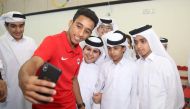 Al Rayyan’s midfielder Ahmed Al Saadi takes a selfie with schoolchildren during a promotional event.  