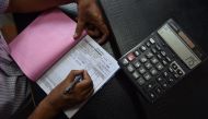An Indian shopkeeper prepares a bill for a customer at his shop in New Delhi on August 3, 2016. AFP Sajjad Hussain 