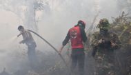 Indonesian firefighters spray water to extinguish a fire in Kampar on September 16, 2019. AFP / ADEK BERRY