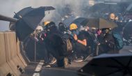 Pro-democracy protesters react after police fired tear gas outside the government headquarters in Hong Kong on September 15, 2019. AFP / Isaac LAWRENCE