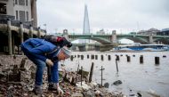 Lara Maiklem, a mudlark searches for treasure at low tide along the river Thames in central London on May 29, 2019. AFP / Tolga Akmen 