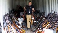 A Chesterfield County police officer sort through thousands of guns found in a home and garage in Pageland, South Carolina, November 10, 2015. Reuters