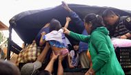 Residents are assisted into a truck after the local government implemented preemptive evacuations at Barangay Matnog, Daraga, Albay province on December 25, 2016 due to approaching typhoon. Nock-Ten / AFP