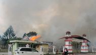A car passes governor office building of Jayawijaya burned during a protest in Wamena, Papua, Indonesia, September 23, 2019 in this photo taken by Antara Foto. Antara Foto/Marius Wonyewun/ via REUTERS 