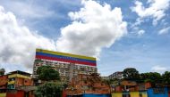 View of a giant Venezuelan national flag sign on top of a building in Caracas, Venezuela, on September 23, 2019. / AFP / Matias Delacroix