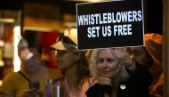A woman holds a sign about whistleblowers in a cafe near U.S. President Donald Trump’s motorcade as he attends a campaign fundraiser nearby in New York, U.S. September 26, 2019. (REUTERS/Jonathan Ernst)