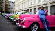 Giovani Bernati, a driver  waits for tourists beside vintage cars used as taxi in Havana, Cuba, October 5, 2018. Reuters / Alexandre Meneghini