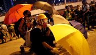 An anti-government protester shelters behind an umbrella as he attends a rally outside the Legislative Council building in Hong Kong, China September 28, 2019. REUTERS/Jorge Silva