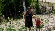 A woman and her son walk in their drought-affected plot, in the southern village of San Francisco de Coray, in the department of Valle, Honduras, August 13, 2015. Reuters/Jorge Cabrera