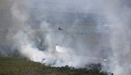 An Indonesian National Disaster Management Agency (BNPB) helicopter dumps water on a burning forest near Banjarmasin in South Kalimantan province, Indonesia, September 29, 2019. REUTERS/Willy Kurniawan 