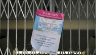 A closure notice by officials sits on the gates of the MTR underground rail system in the Admiralty area in Hong Kong on October 1, 2019, after officials closed off numerous stations across the city as intense protests were expected on the 70th anniversar
