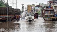 Commuters make their way on a waterlogged road following heavy rainfalls in Patna on September 30, 2019. / AFP / Sachin KUMAR 