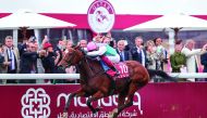 Action from last year’s Qatar Prix de l’Arc de Triomphe at ParisLongchamp. TOP LEFT: A woman walks past a billboard which promotes the premier racing weekend. 