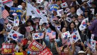 Anti-government protesters shout slogans and wave placards at a rally calling for president Moon Jae-in to step down, in central Seoul on October 3, 2019.   / AFP / Ed JONES