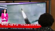 A woman watches a television news screen showing file footage of a North Korean missile launch, at a railway station in Seoul on October 2, 2019.   AFP / Jung Yeon-je
