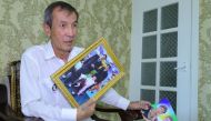 Uzbek journalist and former prisoner Dilmurod Said holds photos of his wife and daughter, who died in a 2009 car crash en route to visit him in a jail, during an interview with AFP in Tashkent on July 26, 2019.  AFP / Temur Ismailov 


