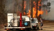 A local resident is seen near a bushfire burning next to Busbys Flat Road in Busbys Flat, northern NSW, Australia, October 9, 2019. AAP Image/Jason O'Brien/via REUTERS