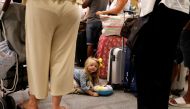 A 3 years old British passenger Indie Robertson lays on the ground as her family queue up at a check-in service at Dalaman Airport after Thomas Cook collapse in Dalaman, Turkey, September 24, 2019. Reuters / Umit Bektas