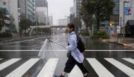A pedestrian with a broken umbrella braves the elements in the Aoyama district of Tokyo on October 12, 2019, as the effects of Typhoon Hagibis begin to be felt in Japan's capital. (AFP / Odd ANDERSEN)