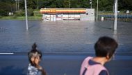 People walk by a flooded convenience store in the aftermath of Typhoon Hagibis in Kakuda, Miyagi Prefecture on October 13, 2019. AFP / CHARLY TRIBALLEAU
