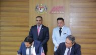H E Ali bin Ahmed Al Kuwari (standing left), Minister of Commerce and Industry; and Datuk Darell Leiking (standing right), Malaysia’s Minister of International Trade and Industry, witnessing the signing of a Memorandum of Understanding between Qatar’s Inv