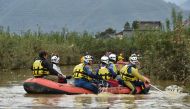 Emergency personnel paddle across floodwaters using an inflatable raft during search and rescue operations in the aftermath of Typhoon Hagibis, in Nagano on October 14, 2019. AFP / Kazuhiro NOGI